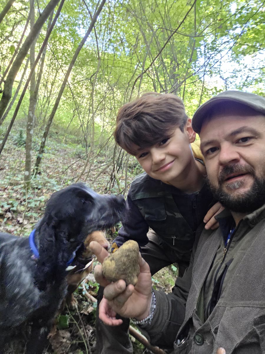 Sandro e Leonardo Cei nel bosco con un tartufo bianco appena trovato e il cocker